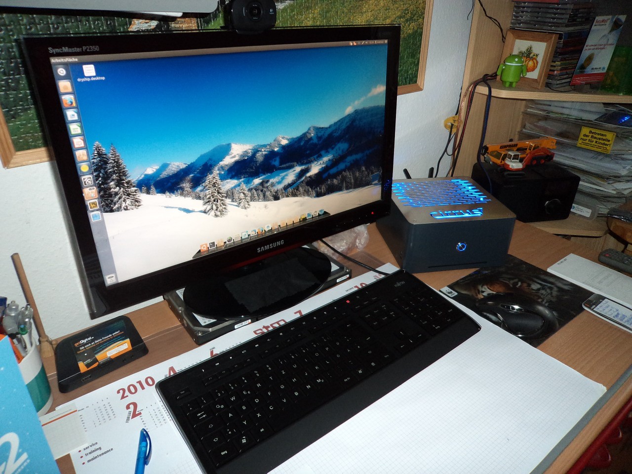 Derselbe Schreibtisch von schräg vorne, der flache cirrus7 One steht neben dem Monitor