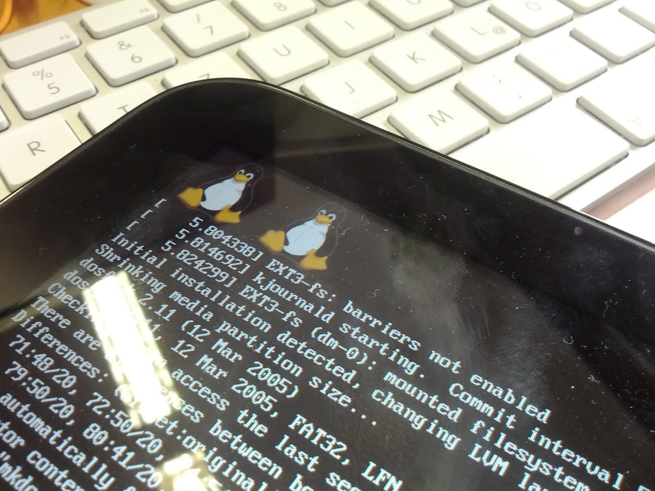 Das Touchpad während der Installation: zwei Tux-Pinguine oben, darunter laufen Kernel-Meldungen durch