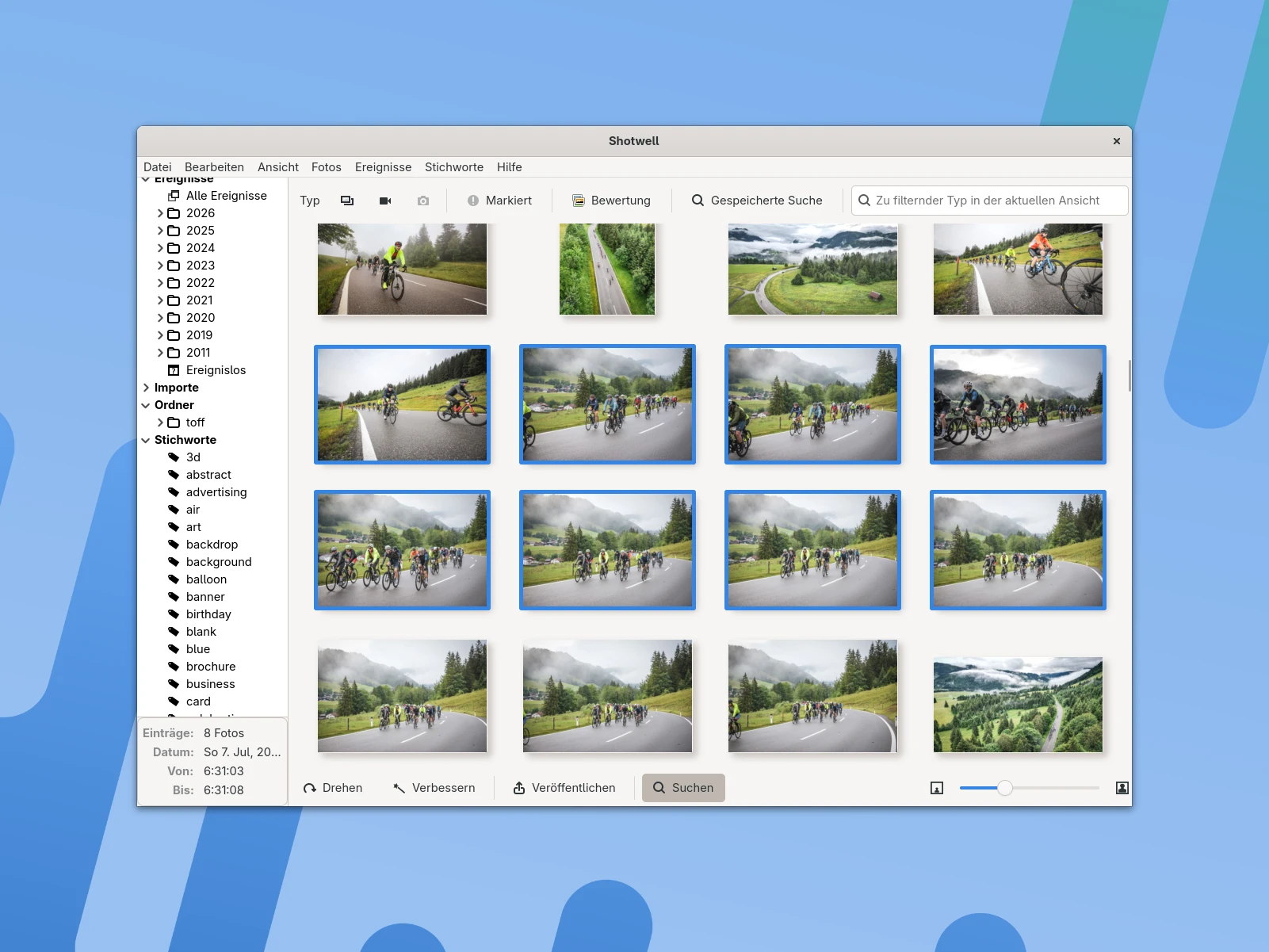 Screenshot einer Softwareoberfläche mit einer Galerieansicht. In der Mitte sind mehrere Vorschaubilder von Radfahrern auf einer Straße und Landschaftsaufnahmen zu sehen. Links befindet sich eine Seitenleiste mit einer Baumstruktur, die verschiedene Jahre und Kategorien aufführt. Oben gibt es eine Menüleiste mit typischen Funktionen wie Bearbeiten, Ansicht und Hilfe. Der Hintergrund ist hellblau mit abstrakten Formen.